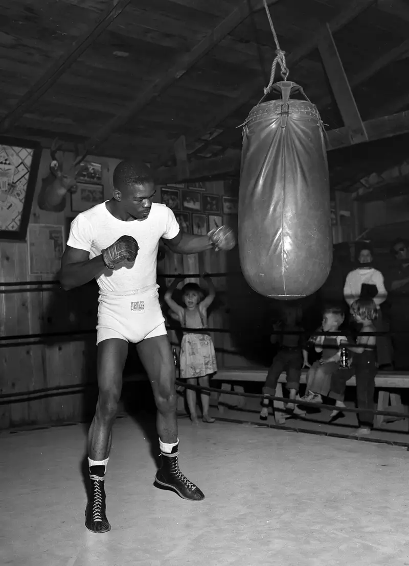 A boxer training on the heavy bag in an old-school gym