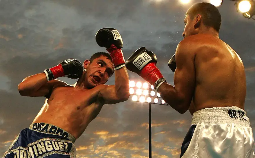 Two boxers mid-bout under the lights — Cuban sport, up close