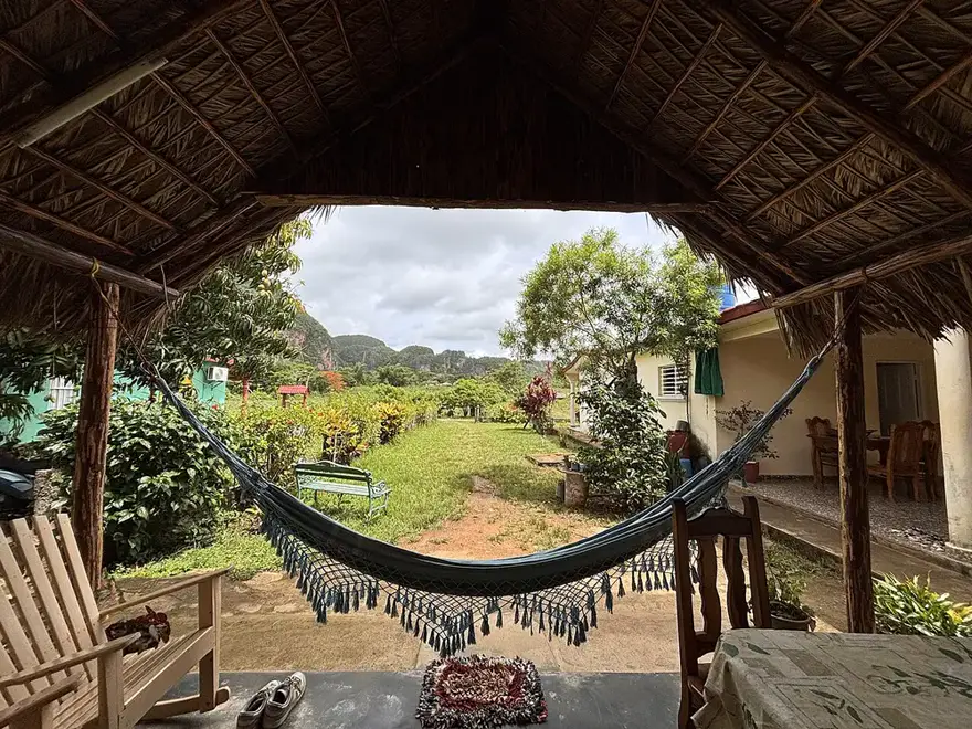 A bohío porch with a hammock overlooking the green Viñales valley